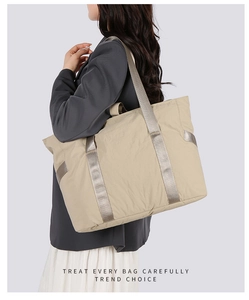 Détail du sac cabas beige montrant la texture du tissu et la poignée renforcée robuste