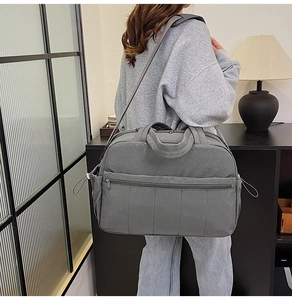 Large grey travel handbag with multiple pockets and shoulder strap for weekend trips
