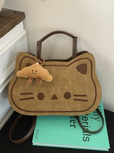 Cute cat-shaped beige backpack for women with brown handles and croissant charm