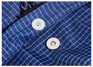 Macro view of blue plaid fabric showing magnetic buckle and adjustable drawstring detail