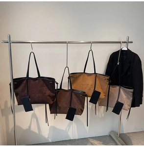 Dettaglio di quattro borse tote vintage in pelle scamosciata con scritte in rilievo e pochette