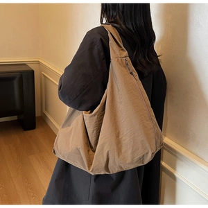 Gros plan d'un sac cabas kaki avec texture en nylon froissé et fermeture éclair latérale