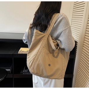 Model showing large khaki tote bag back view for daily use and shoulder fit