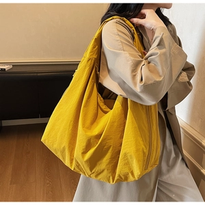 Détail d'un grand sac bandoulière jaune souple avec texture plissée naturelle