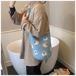 Close-up of blue fleece bucket bag featuring white lamb pattern and soft texture detail
