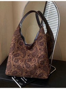 Retro paisley tote bag in brown fabric with leather straps shown on a stylish studio setup