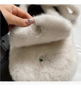 Détail du sac à main en peluche blanche avec une boucle magnétique ronde en métal argenté