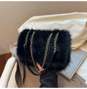 Close-up of black faux fur shoulder bag with gold metal chain strap and soft texture