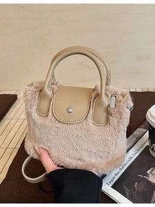Chic beige faux fur handbag with leather handle and round buckle in a warm setting