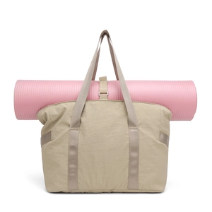 Détail d'un sac de yoga kaki montrant un tapis de yoga rose fixé par des sangles