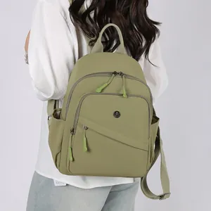 Detail view of olive green lightweight nylon backpack with multiple zipper compartments