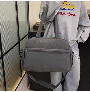Detail of gray large capacity travel bag featuring adjustable padded shoulder strap
