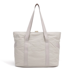 Gros plan sur un sac fourre-tout gris clair montrant la texture du nylon et les poignées