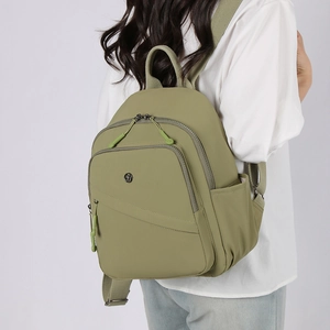 Detail view of olive green lightweight nylon backpack with large front zip pocket