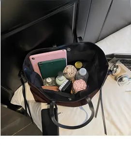Vista dall'alto della capiente borsa tote in pelle scamosciata marrone con accessori