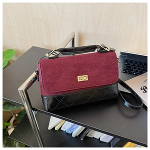 Détails de la suédine bordeaux et du fermoir doré sur le sac à main matelassé