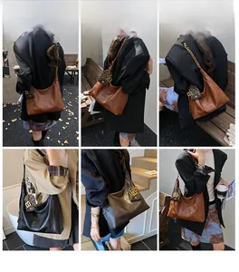 Makroansicht einer großen Hobo-Tasche aus Leder mit Metallkette und Leopardenmuster-Anhänger
