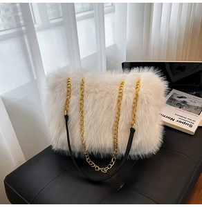 Detail of white faux fur tote with gold metal chain and black leather shoulder strap