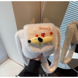 Détail d'un sac à main en fausse fourrure crème avec un écusson de chiot dessin animé mignon