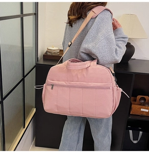 Pink quilted canvas travel bag with adjustable strap and side drawstring pockets