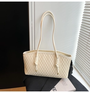 Vue détaillée de la texture plissée en cuir PU blanc cassé et de la sangle nouée élégante