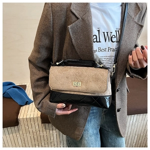 Détail du sac bandoulière matelassé bicolore avec fermoir doré sur une veste marron