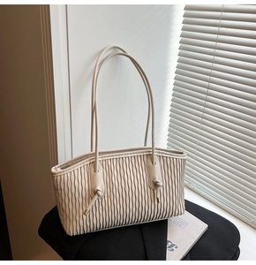 Vue détaillée de la texture plissée beige et du nœud décoratif en métal doré chic