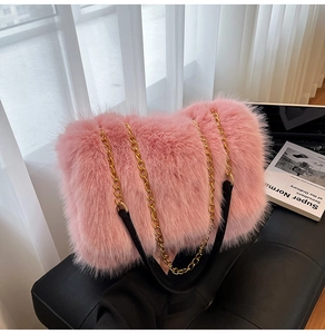 Close-up of pink faux fur tote bag with golden chain and black leather strap details