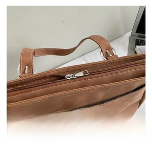 Détail de la boucle en métal argenté et de la fermeture éclair du sac cabas en daim marron