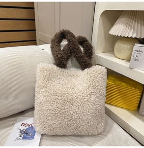 Dettaglio della borsa tote in peluche crema e marrone su un comodo divano