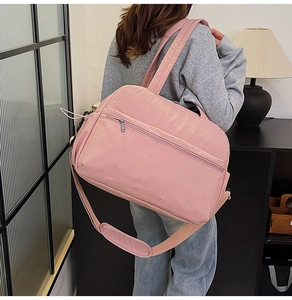 Lifestyle shot of large pink travel bag with adjustable strap and front zipper pocket