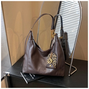 Nahaufnahme der braunen Leder-Tote-Bag mit Metallkette und Leopardenmuster-Anhänger