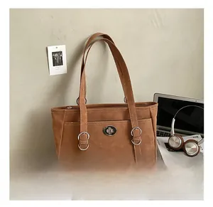 Détails du sac cabas en daim marron avec fermoir rotatif argenté et doubles poignées