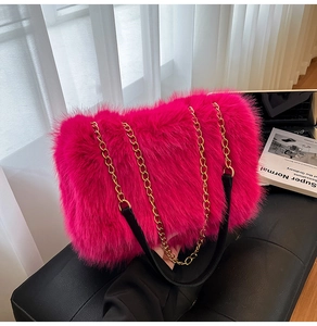 Close-up of fluffy pink faux fur shoulder bag texture with golden metal chain strap