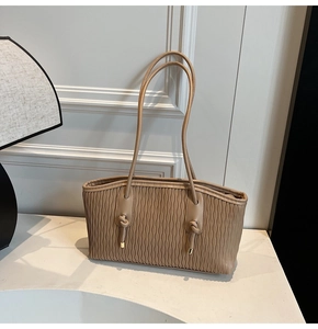 Vue détaillée du sac cabas beige avec texture plissée verticale et anses nouées