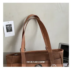 Détail du sac cabas vintage marron avec surpiqûres blanches et fermoir en métal poli