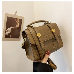 Close-up of vintage brown PU leather bag with star stitching and gold metal buckle