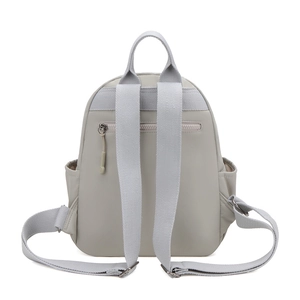 Detail view of mini backpack back with anti-theft zipper pocket and gray straps