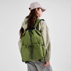 Detail of light green grid drawstring backpack with adjustable cords and mesh side pockets