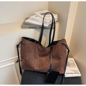 Dettaglio borsa tote in pelle scamosciata marrone caffè con logo e astuccio con zip