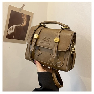 Detail of vintage dark brown PU leather crossbody bag with star gold buckle and embossed logo