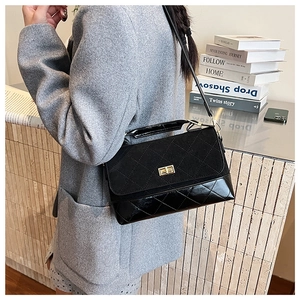 Détail du sac bandoulière matelassé noir avec fermoir doré et textures en daim chic