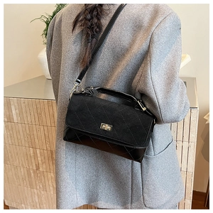 Détail du sac à bandoulière matelassé noir avec fermoir doré et base en cuir lisse