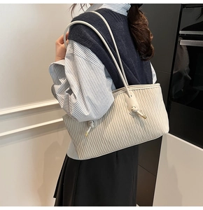 Détail du sac fourre-tout matelassé crème avec surpiqûres ondulées et fines lanières
