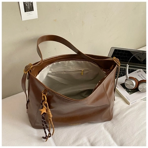 Détail d'un cabas marron vintage montrant l'espace intérieur et la poche zippée