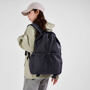 Macro detail of black checkered drawstring backpack with durable nylon fabric and thick cords