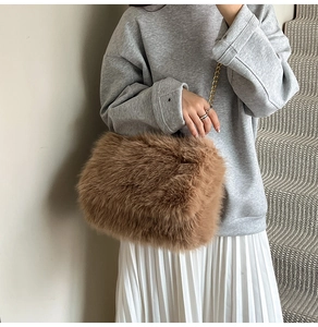Detail of soft brown faux fur shoulder bag with elegant gold metal chain strap