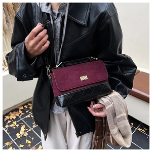 Détail du sac bandoulière vintage en suède bordeaux avec motif losange et fermoir doré