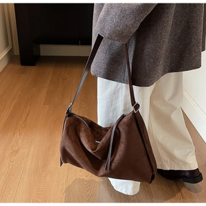 Deep brown suede hobo bag shown in a professional lifestyle setting with soft lighting
