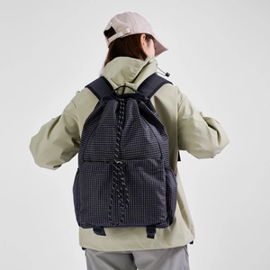 Detail of black grid ripstop drawstring backpack with metal ring and wide straps